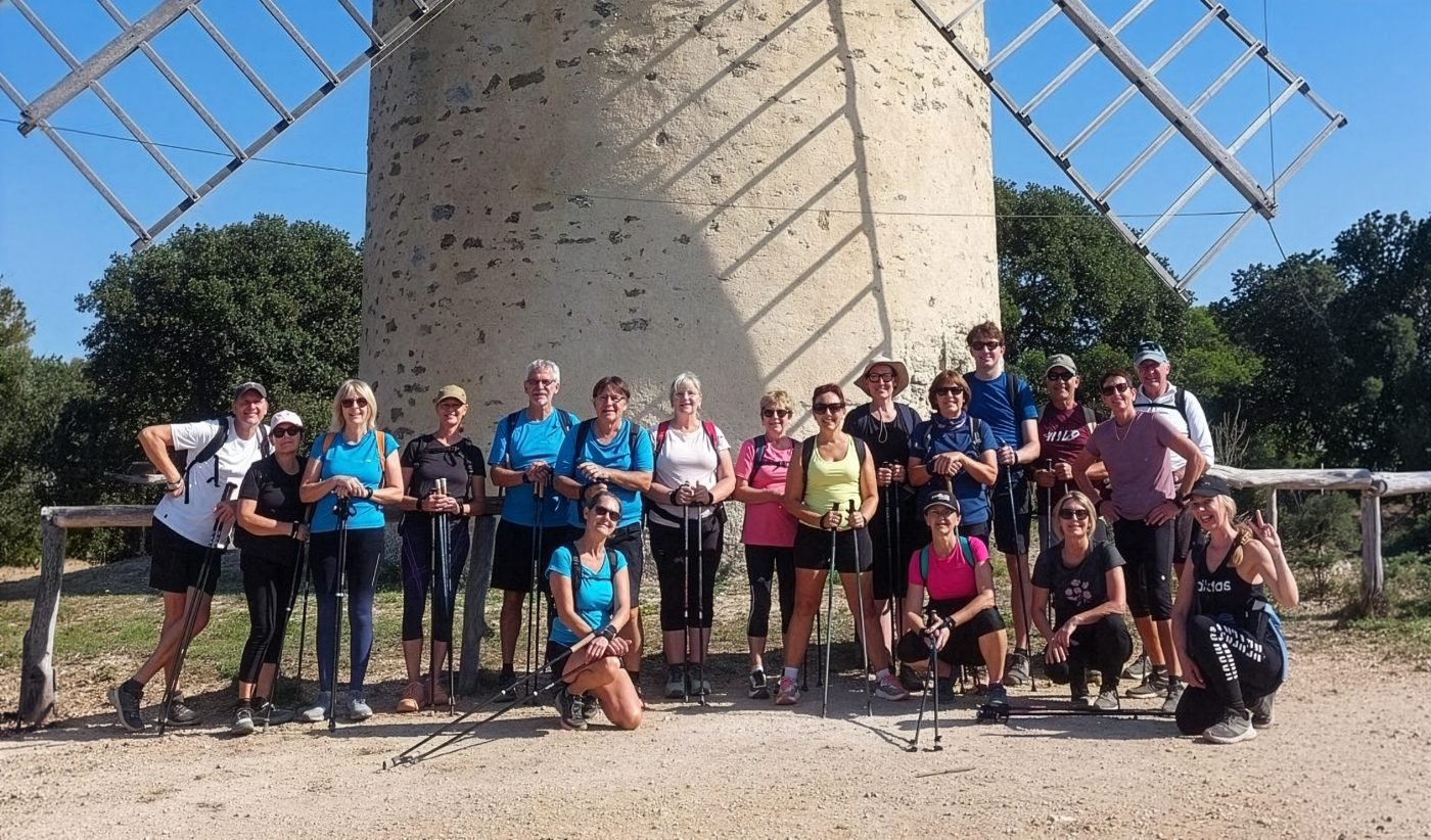 Photo de groupe du club de marche nordique de Hyères devant le moulin de Porquerolles, balade en bord de mer sur la Côte d'Azur, dans le Var, avec bâtons de marche nordique.